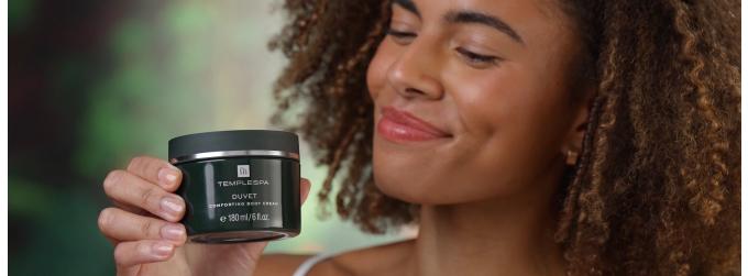 Lady smiling and smelling our product Duvet a comforting body cream
