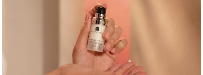 Windows of the soul eye cream being held with lid off and one pump of product on finger