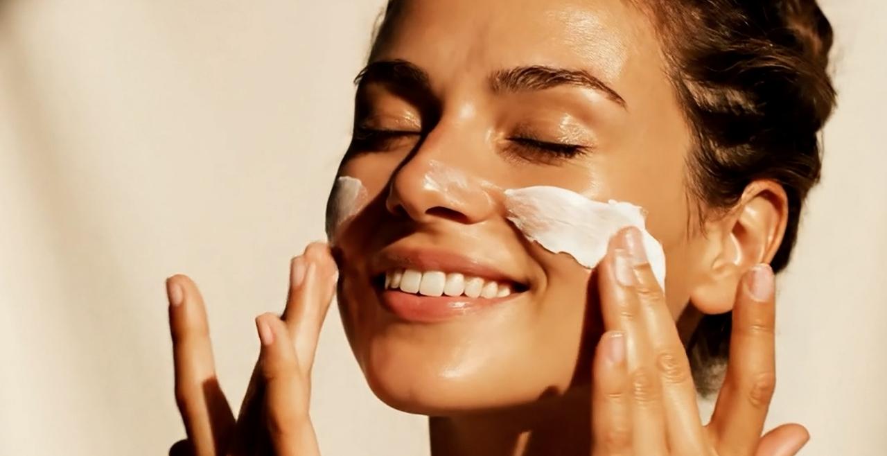 Smiling woman applying SPF Moisturiser.