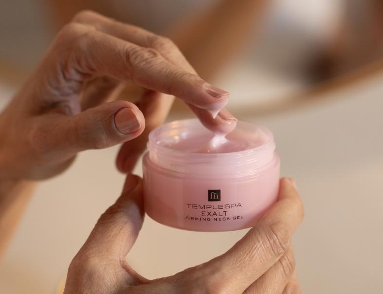 exalt firming neck gel product with hand dipping into the product
