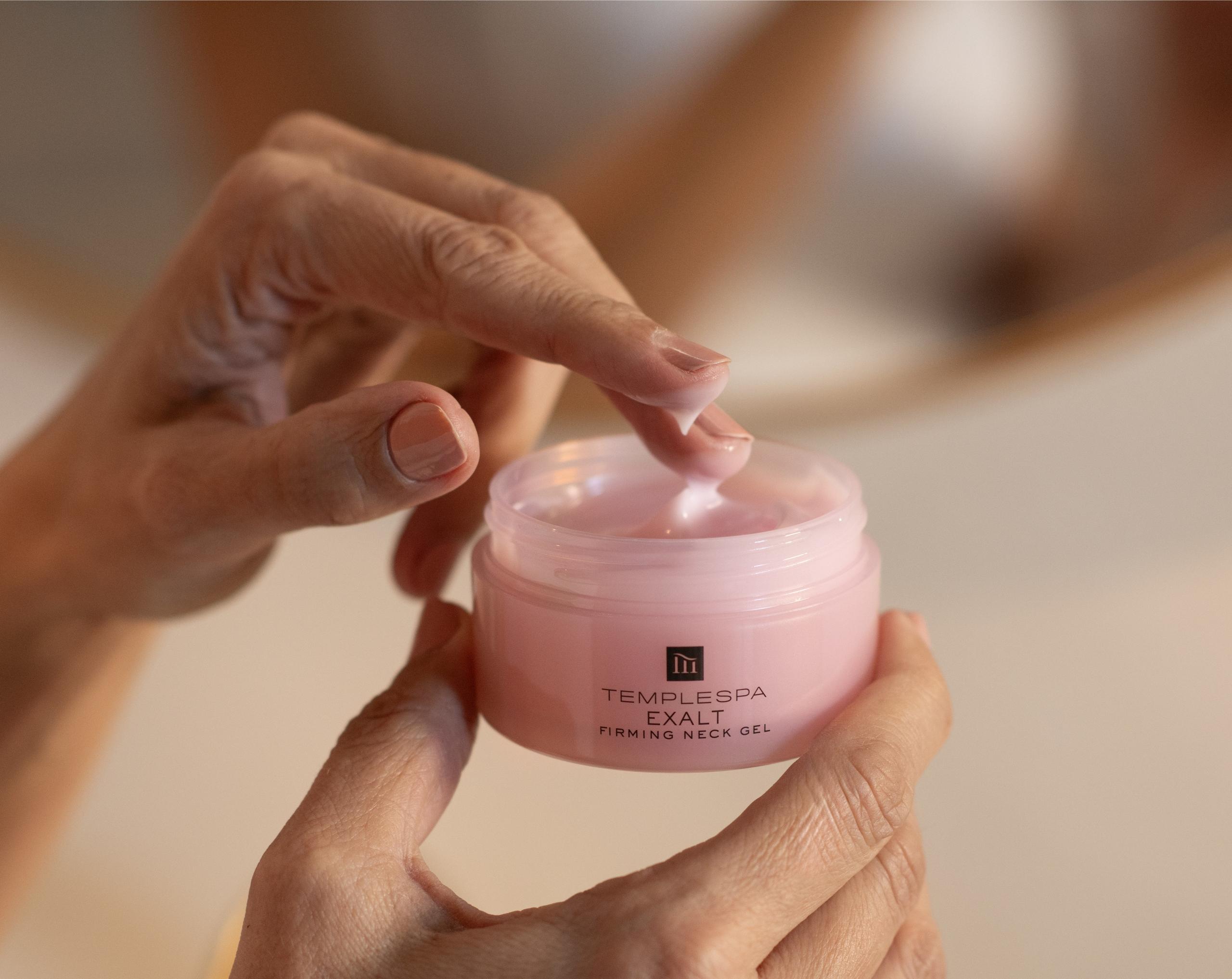 exalt firming neck gel product with hand dipping into the product