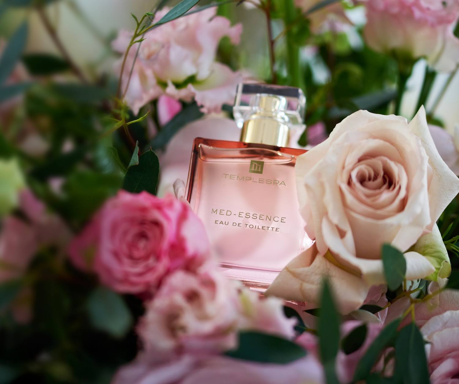 Our Med Essence fragrance amongst pink and white roses 